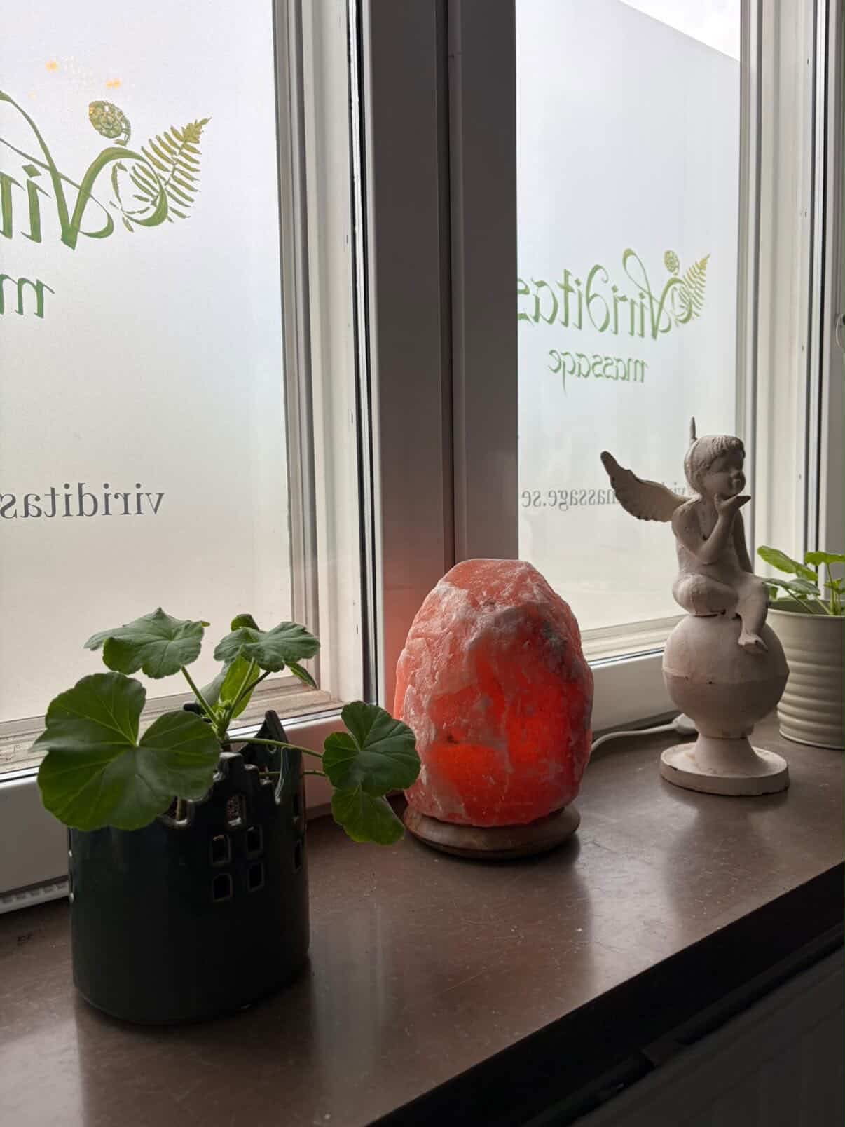 Fönsterbräda med saltkristallampa, ängel och växter i Viriditas salong